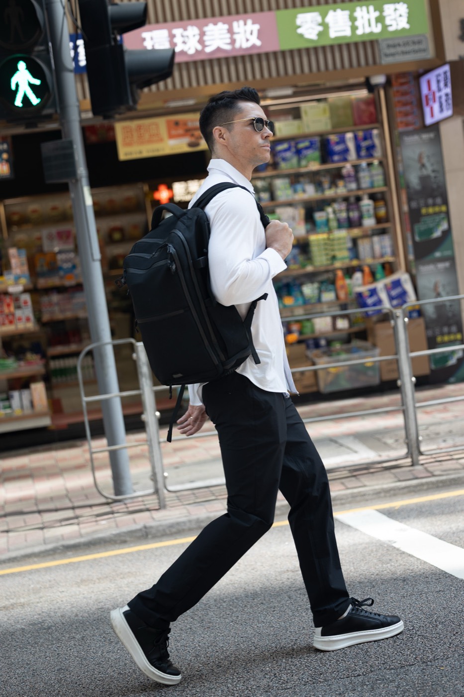 Crossing a Hong Kong street in All Rounder Urban, backpack on one shoulder.